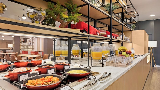 A buffet area with various food stations, including pasta, salads, and fruit. - Ramada by Wyndham Valencia Almussafes (Almussafes)