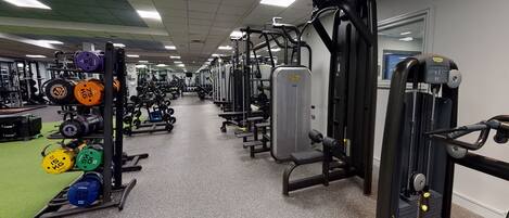 A gym with various weightlifting equipment, treadmills, and cardio machines.