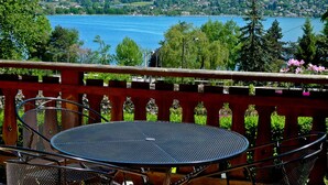 A balcony with a round metal table and chairs, overlooking a lake with a mountainous backdrop. - Hotel des Marquisats Annecy (Annecy)