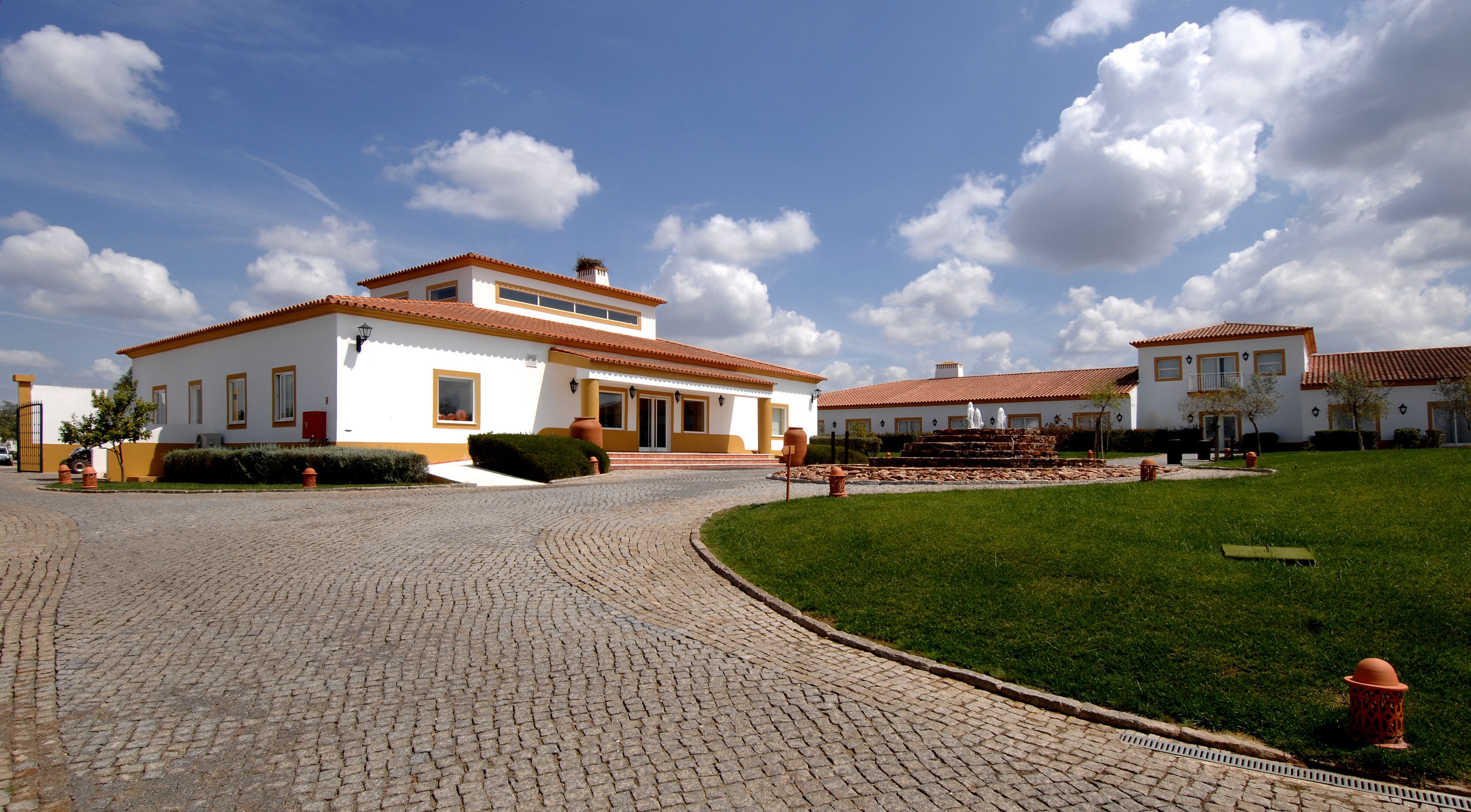 A two-story building with a paved driveway leading to a gated entrance.