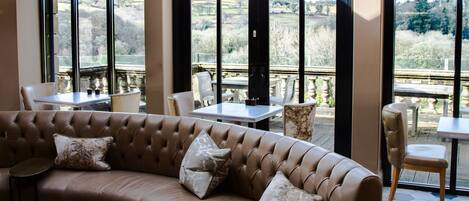 A modern lounge area with a curved leather sofa, a round coffee table, and a patterned tile floor.