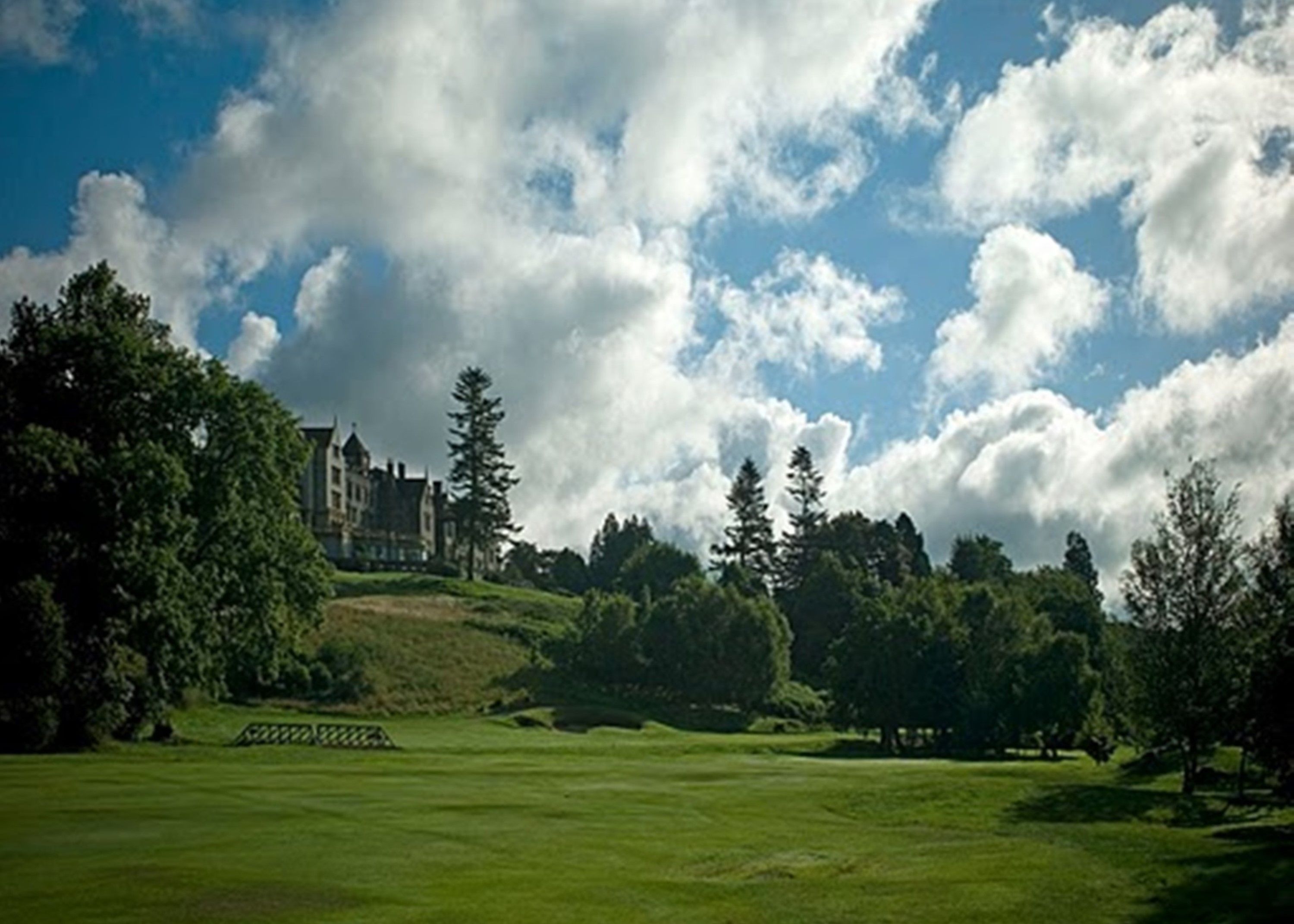 A golf course with a large building in the background.