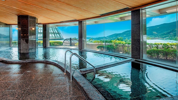 Une piscine intérieure moderne offrant une vue sur un paysage montagneux.