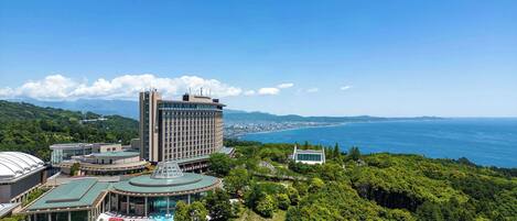 Un hotel con un edificio grande, una piscina y vistas al mar.