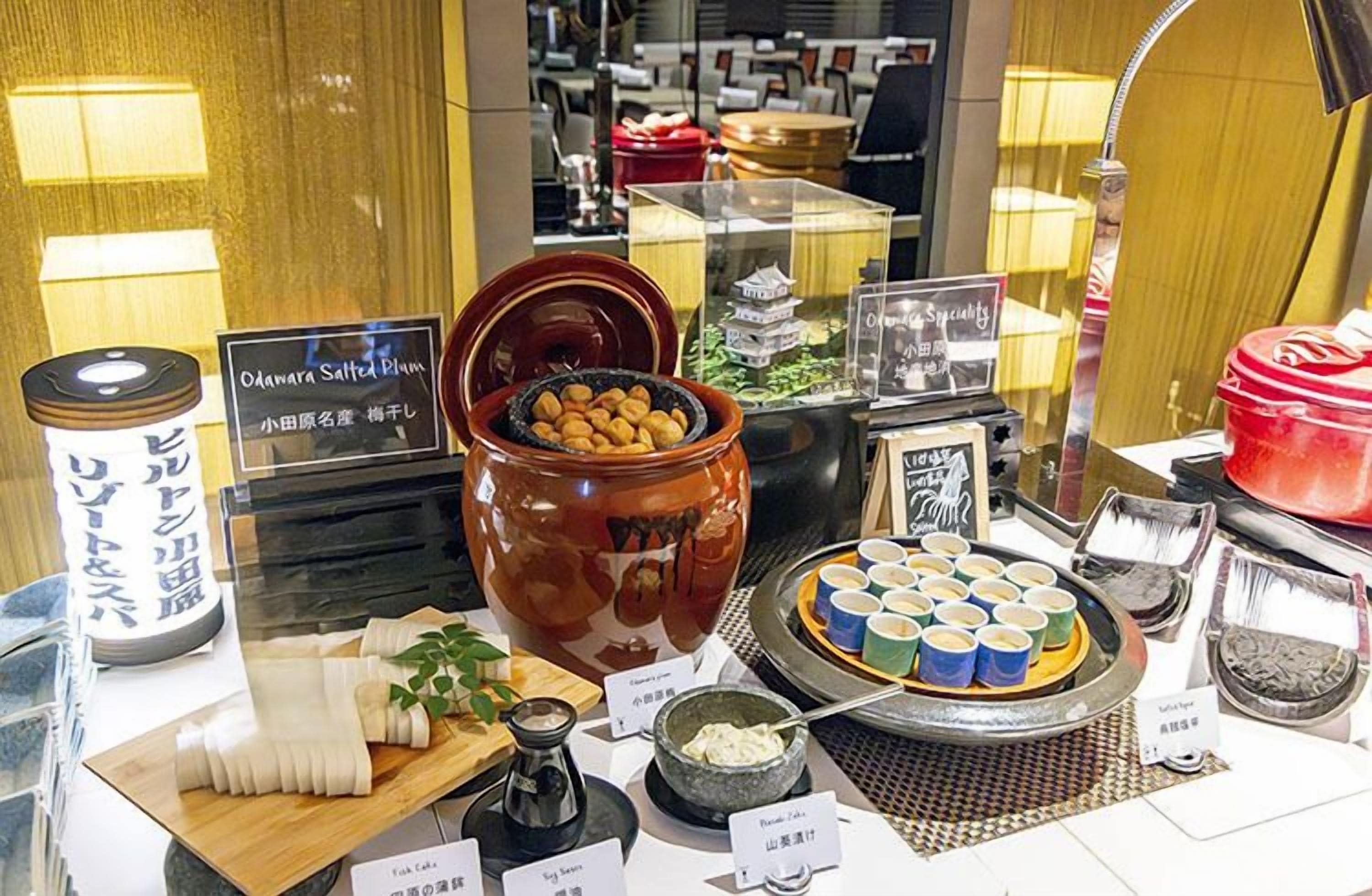 A display of various Japanese sweets and snacks, including a large ceramic jar of mochi and a selection of colorful mochi cups.