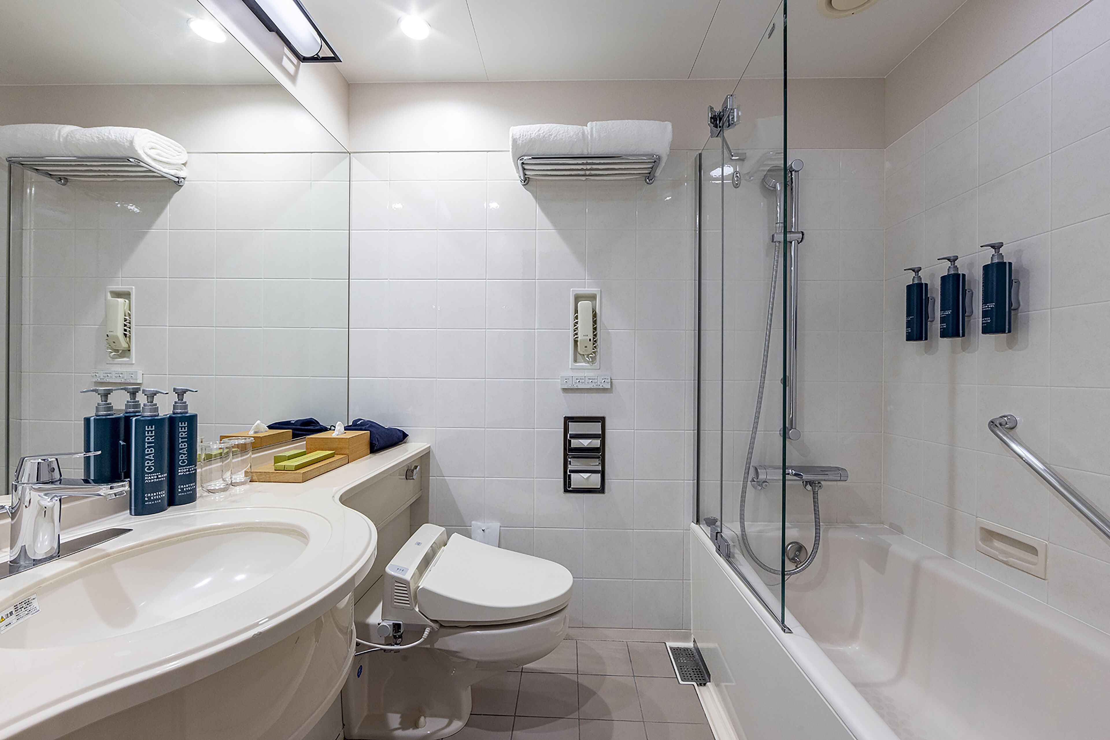 A modern bathroom with a large sink, toilet, and shower area.