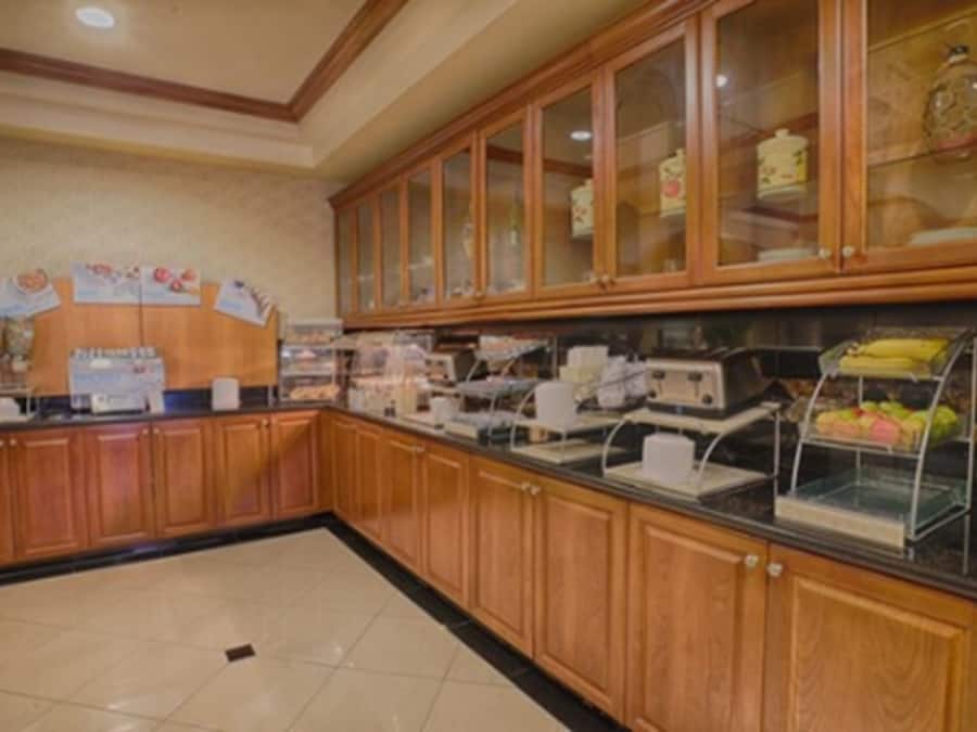 Un espace buffet doté de meubles en bois et d’une vitrine en verre.
