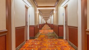 A hotel hallway with carpeted floors, wooden doors, and a long corridor. - Holiday Inn Express & Suites Tucson Mall by IHG (Tucson)