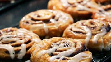 A tray of freshly baked cinnamon rolls with icing.
