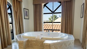A hot tub in a room with a view of a building with a tiled roof. - Holiday Inn Express & Suites Tucson Mall by IHG (Tucson)