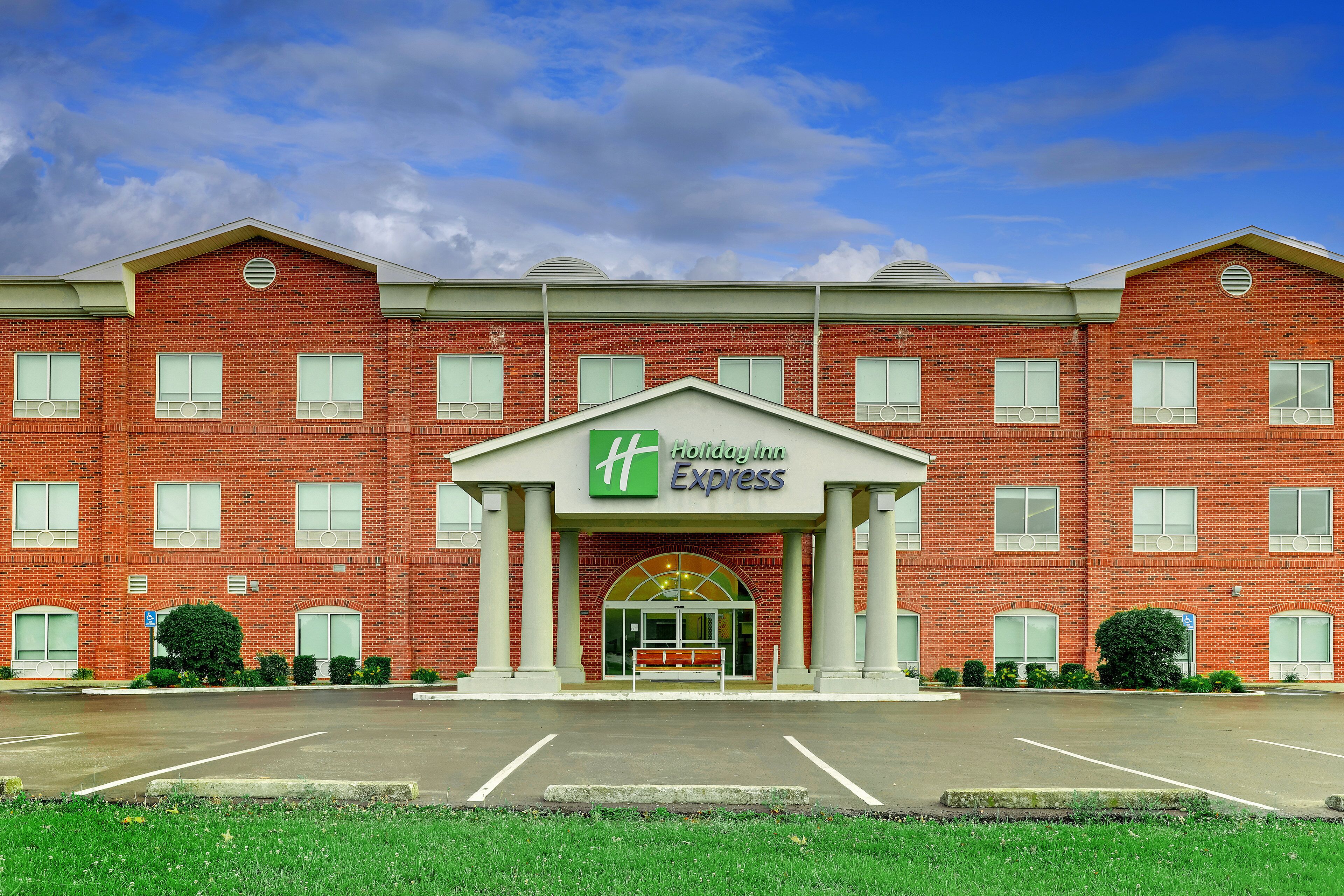Un hôtel Holiday Inn Express avec une façade en briques, de grandes fenêtres et une entrée centrale.