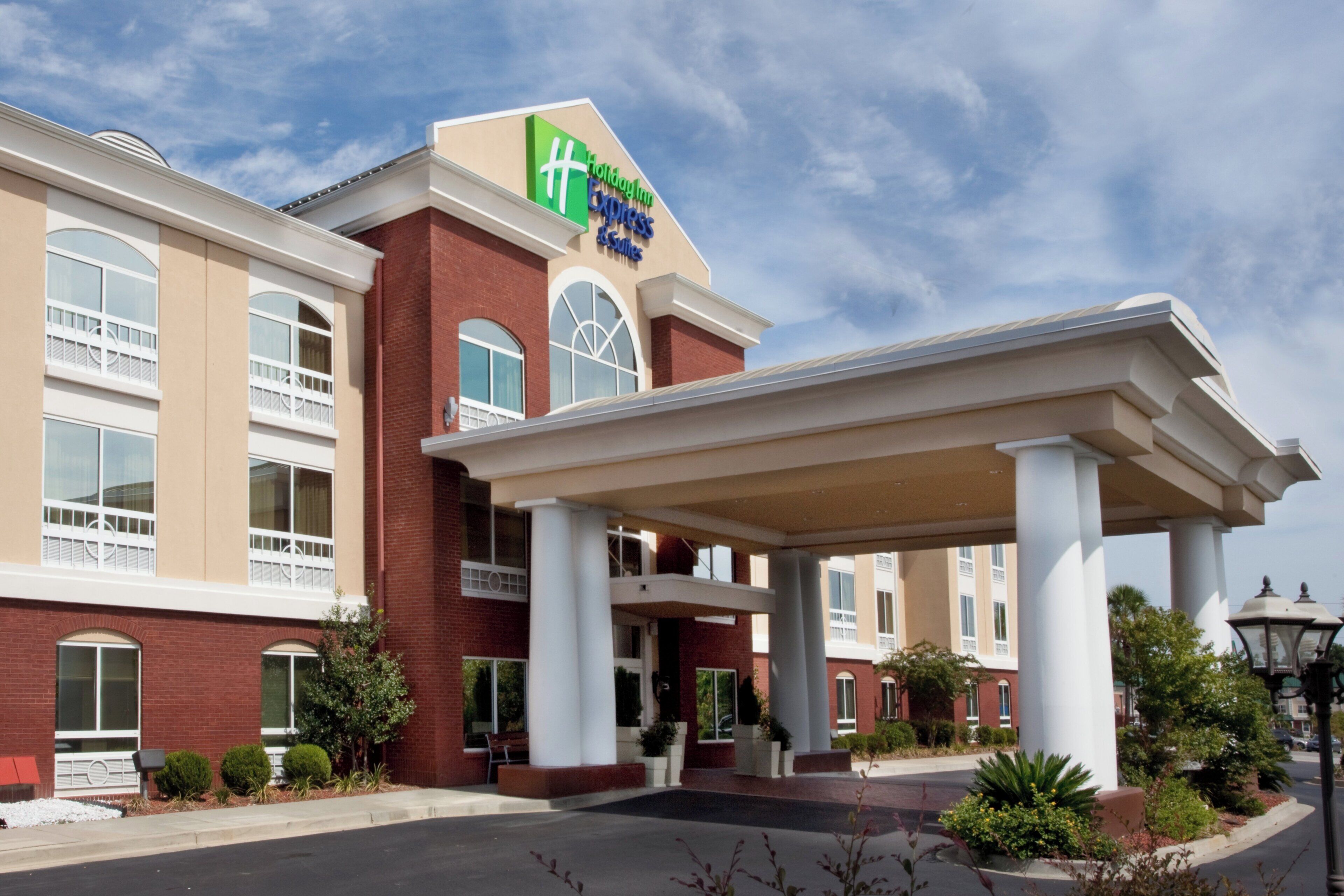 A Holiday Inn Express hotel with a brick facade, large windows, and a covered entrance.