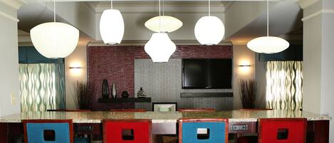 A modern kitchen with a large island, bar stools, and pendant lighting.