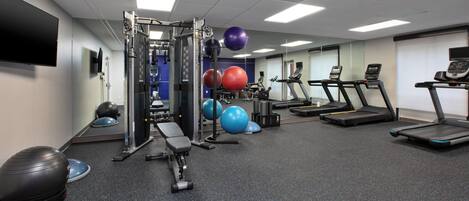 A gym with treadmills, exercise balls, and weight machines.