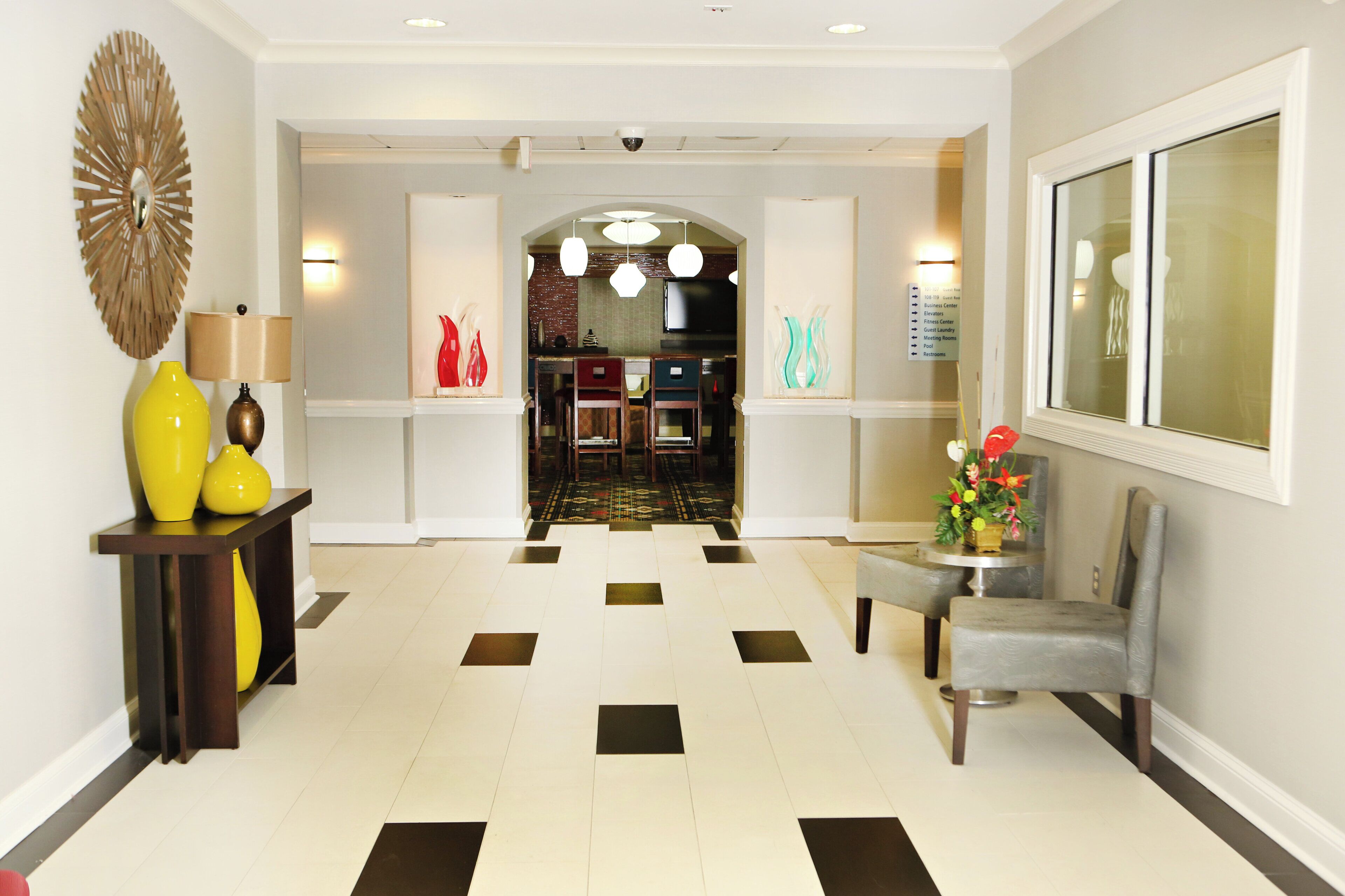 A hotel lobby with a check-in desk, a reception area, and a seating area.