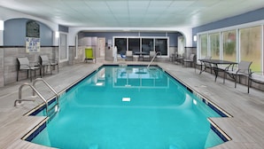 An indoor swimming pool with clear blue water, surrounded by tiled walls and a ceiling with a grid pattern. - Holiday Inn Express Sumter by IHG (Sumter)