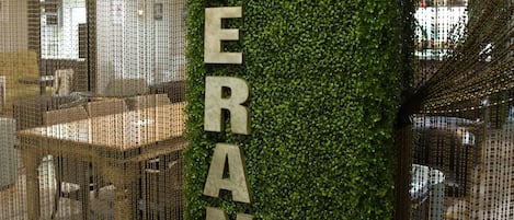 A modern interior with a vertical garden wall and a sign reading "ESPERANTO".