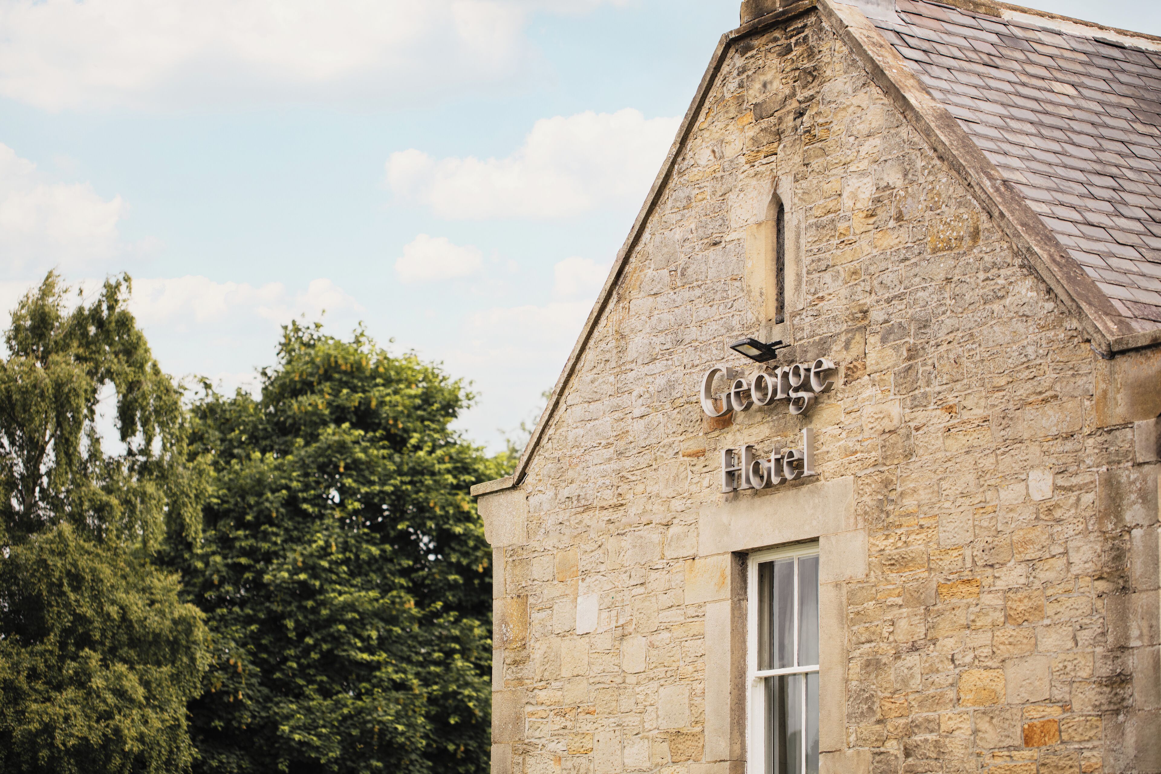 A stone building with a sign reading "George Hotel."