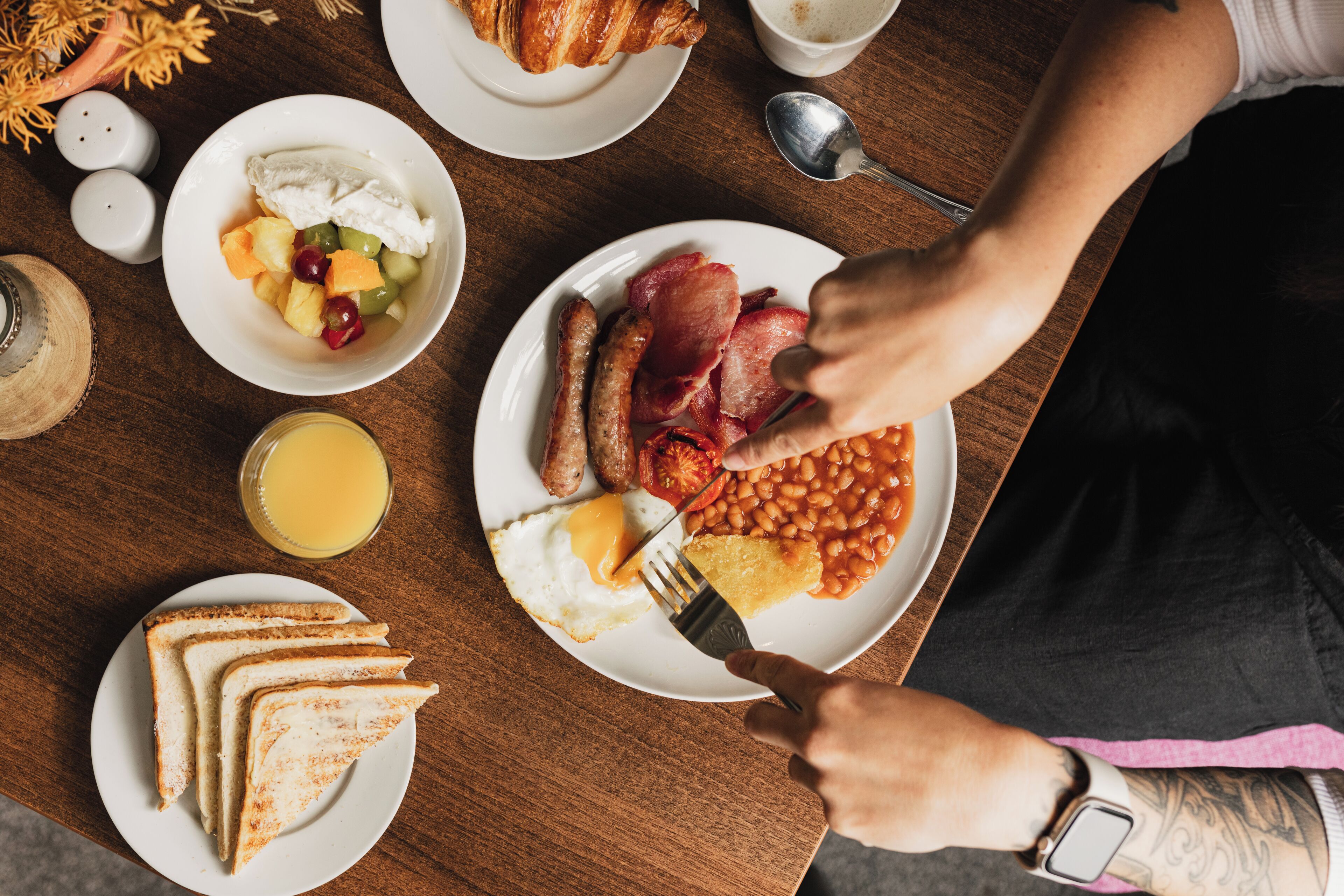 A breakfast plate with eggs, bacon, beans, and toast.