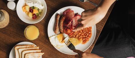 Un plato de desayuno con huevos, tocino, frijoles y tostadas.