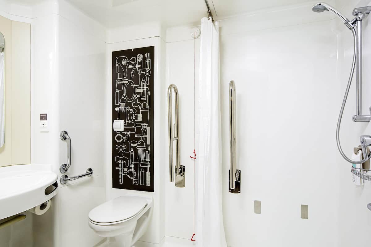 A modern bathroom with a toilet, a shower, and a sink.