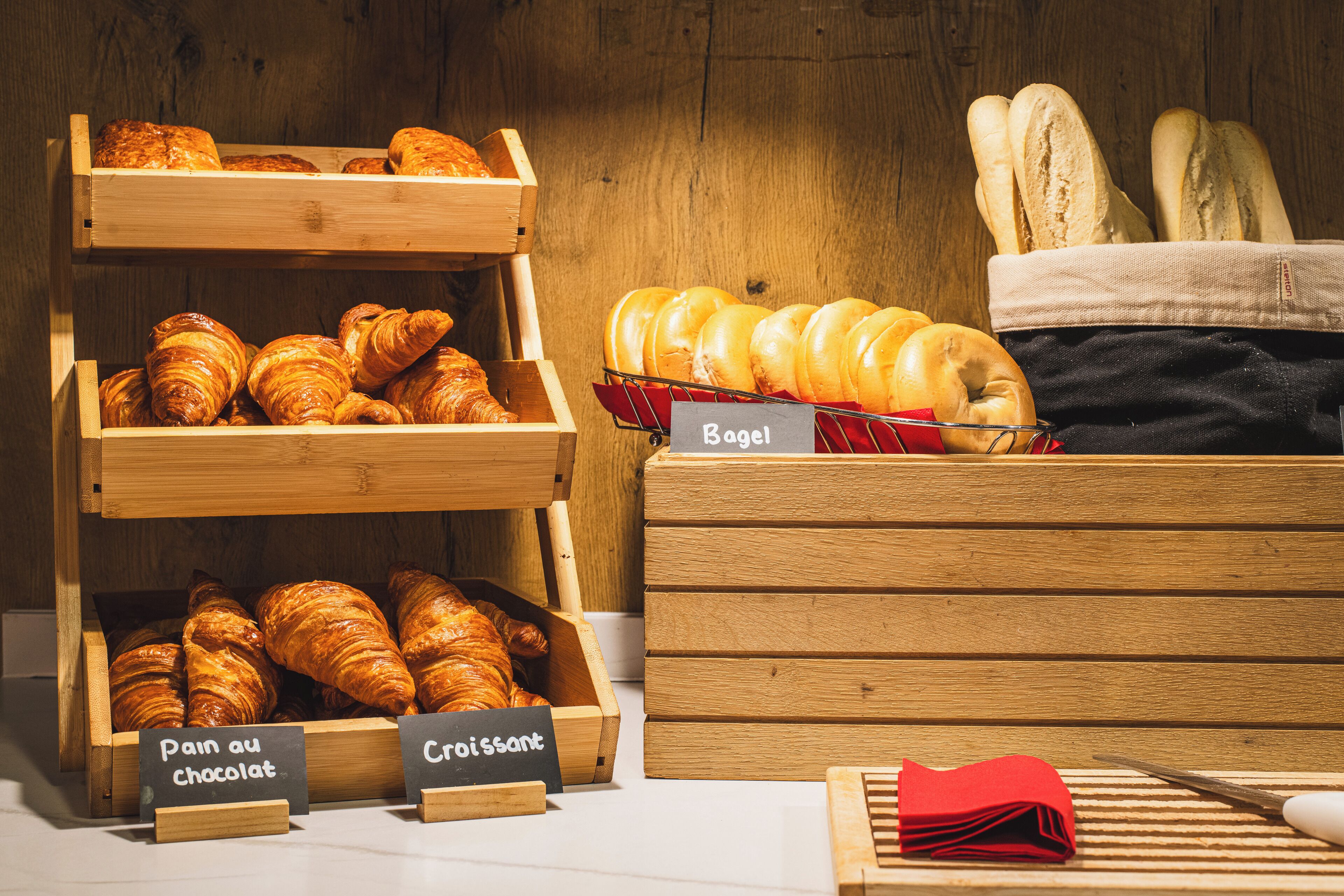 A bakery display with croissants, bagels, and a sign indicating 'Pain au chocolat' and 'Croissant'.