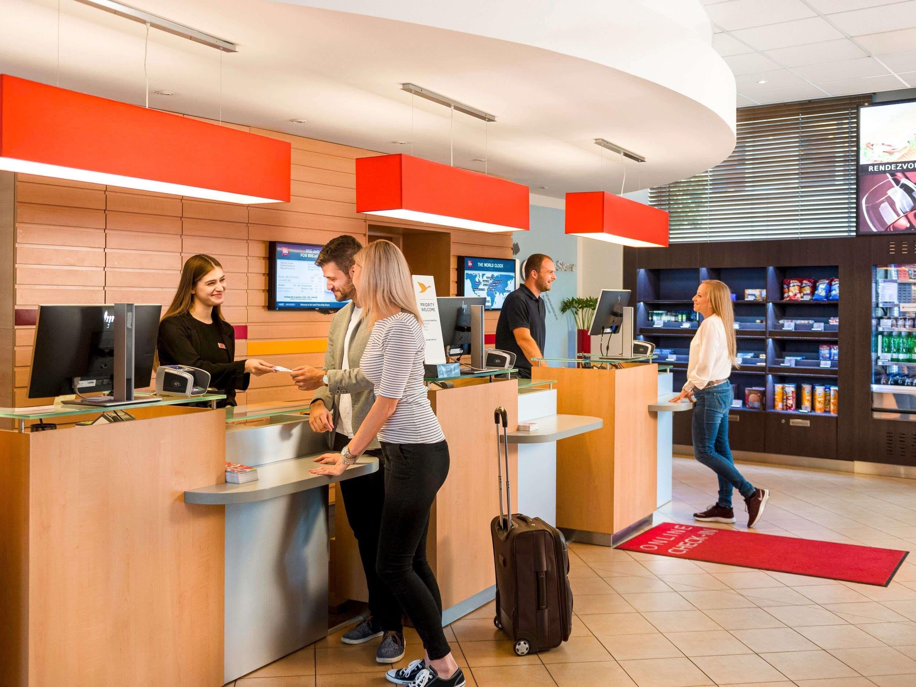 A reception area with a counter, computers, and a digital screen.