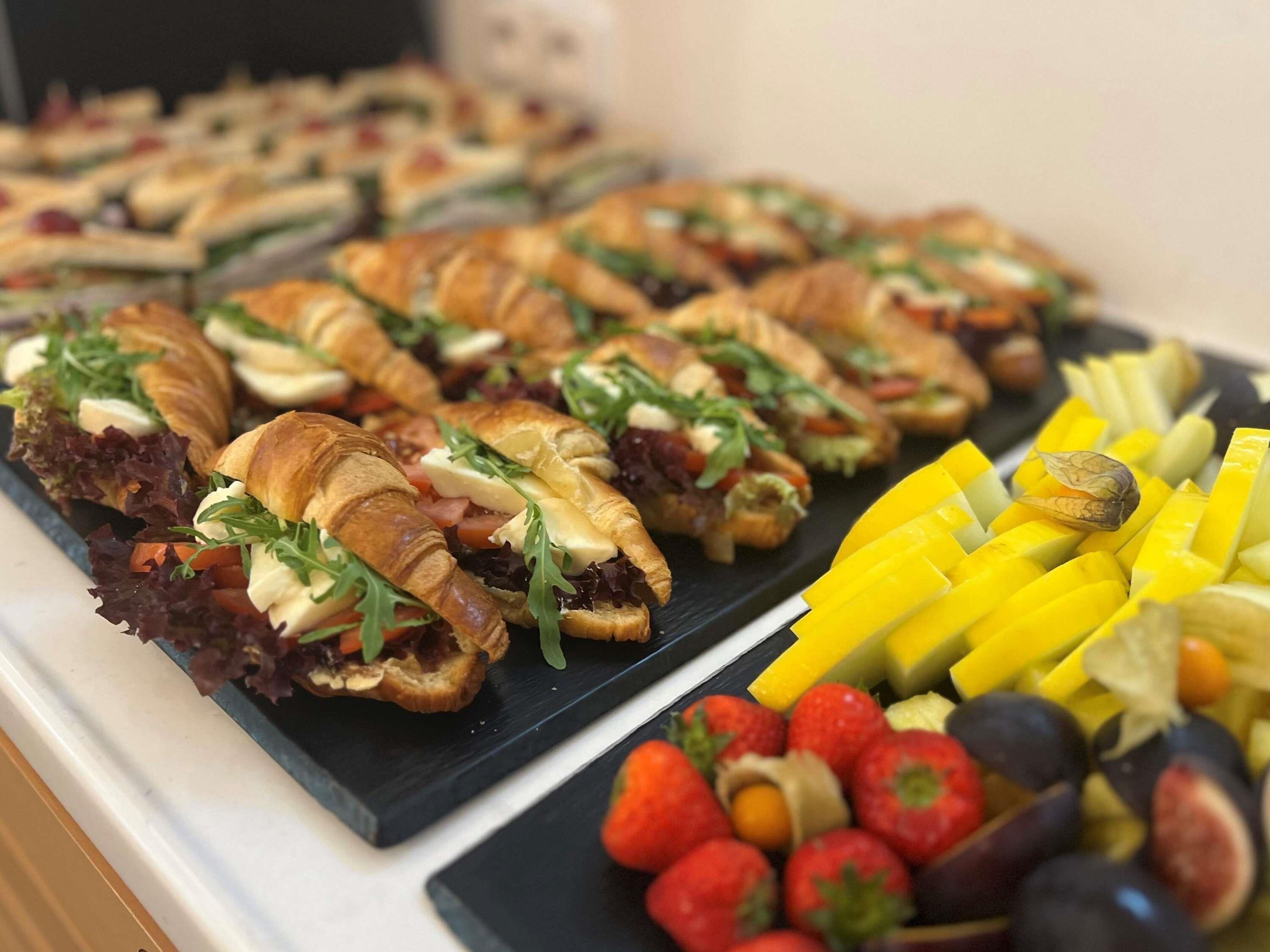 A buffet with crostini, fresh fruits, and vegetables.