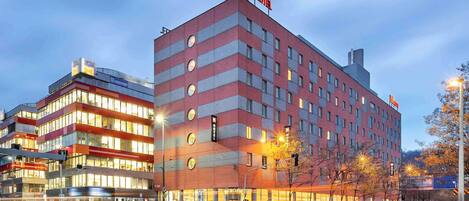 Un hotel de diseño moderno, con varios pisos y un llamativo letrero de 'ibis Hotel'.