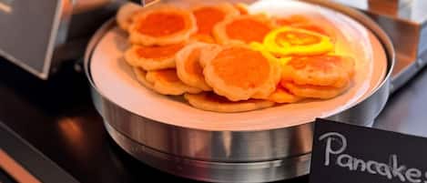 Una pila de panqueques sobre un plato de metal con un letrero que muestra el precio.