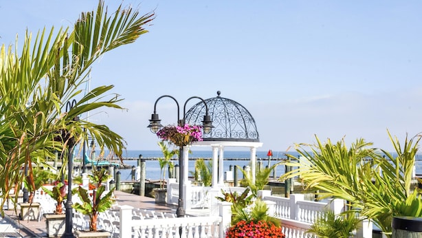 A gazebo with a dome, surrounded by a white fence, near a waterfront with a clear sky. - Rod 'N' Reel Resort (Chesapeake Beach)