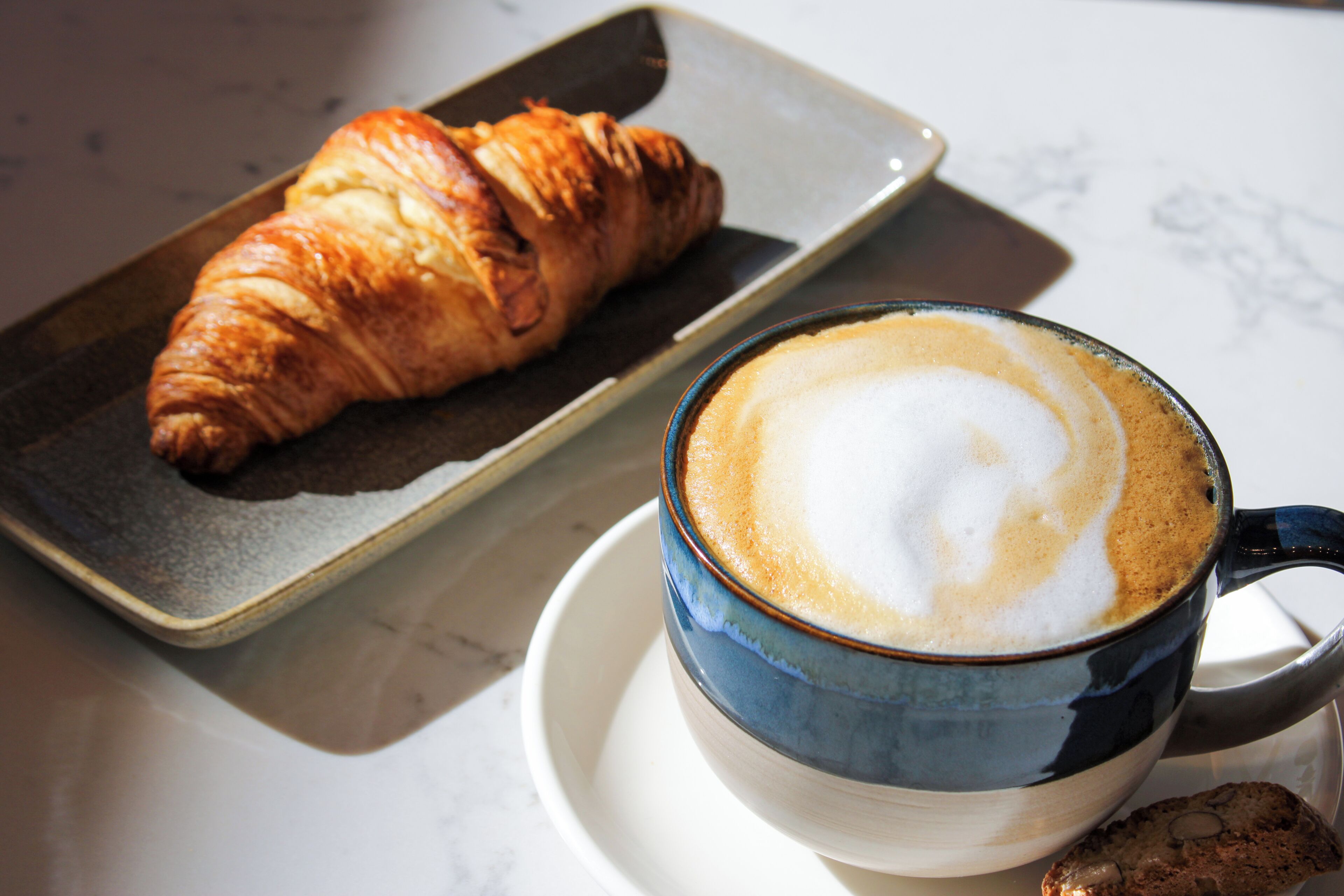 Un croissant et une tasse de café sur une table.