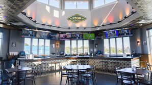 A restaurant with a high ceiling, large windows, and a central bar area. - Rod 'N' Reel Resort (Chesapeake Beach)