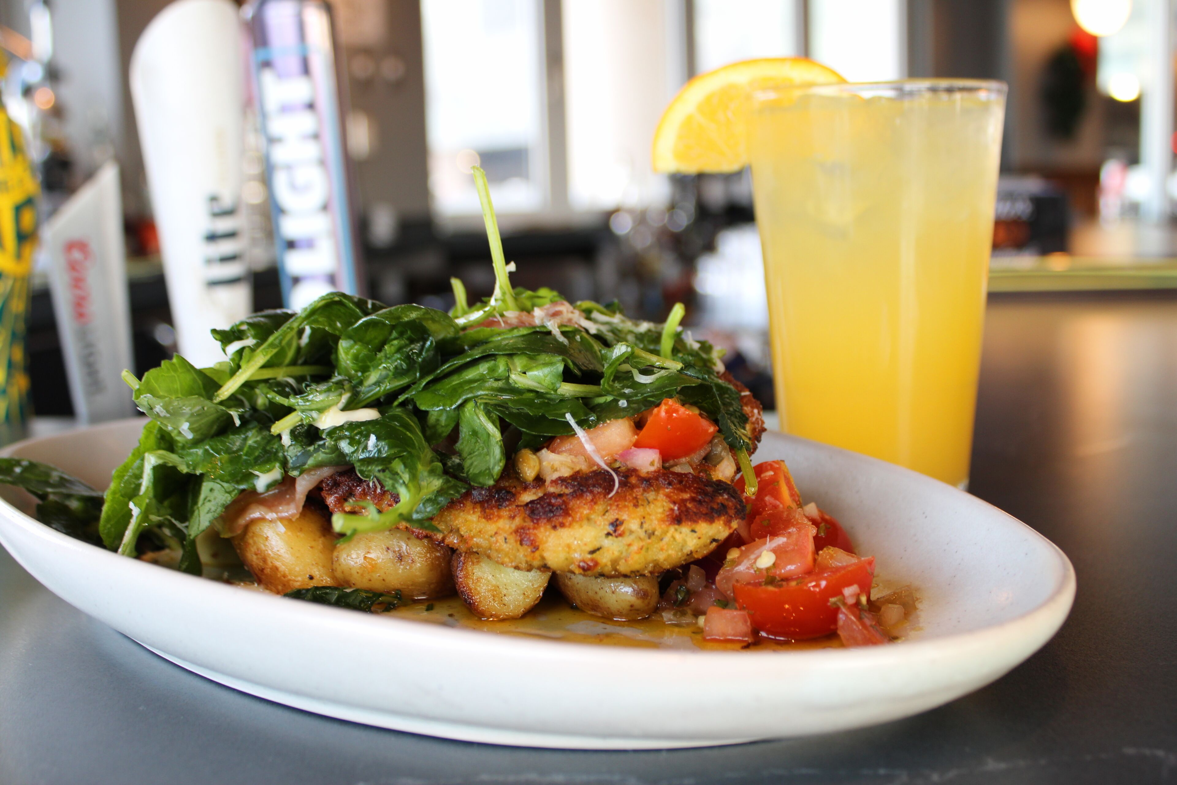 A plate of food with a glass of orange juice.