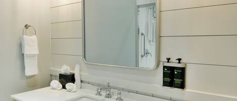 A modern bathroom with a large mirror, dual sinks, and a towel rack.
