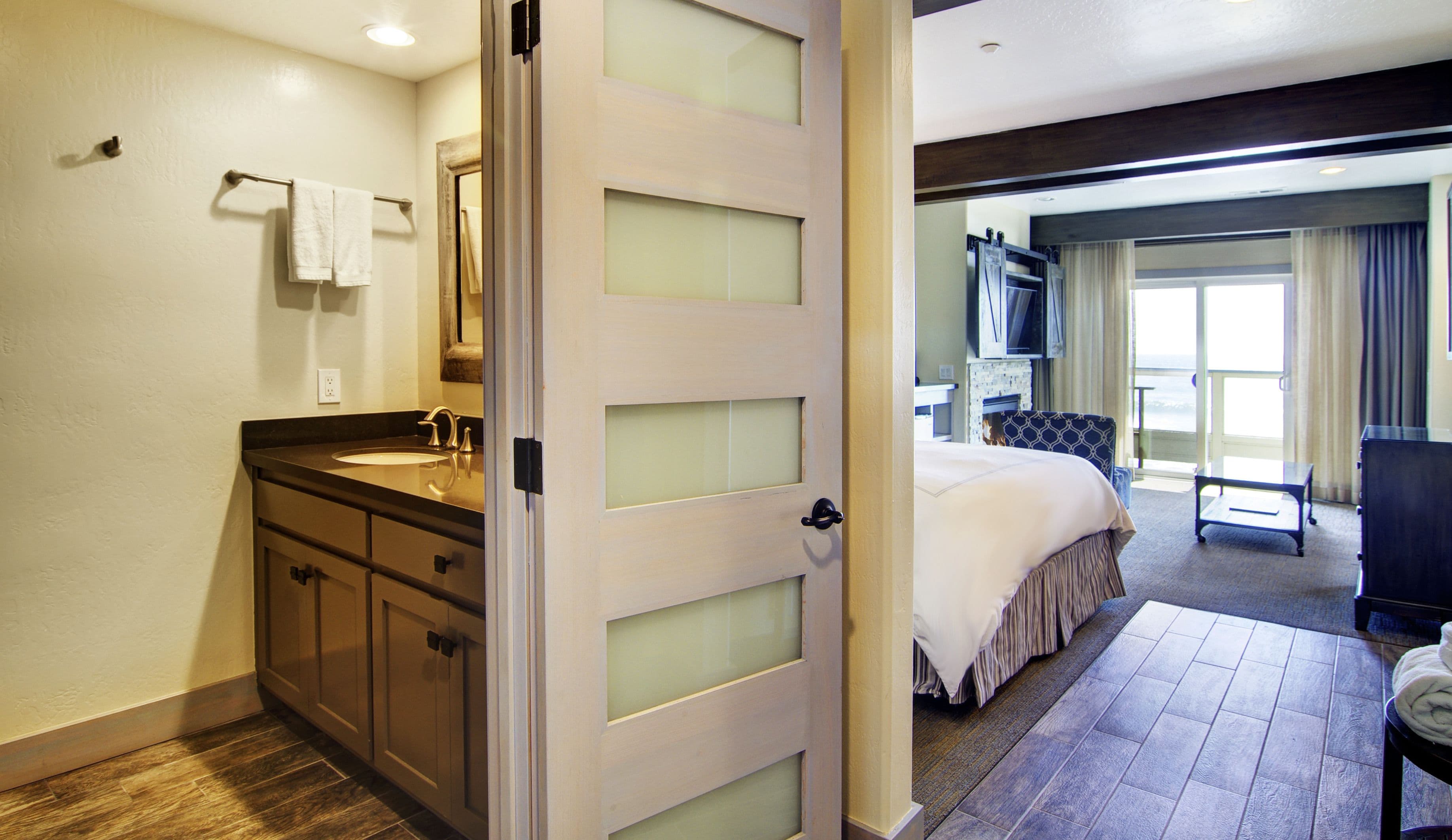 A hotel bathroom with a sink, mirror, and towel rack.