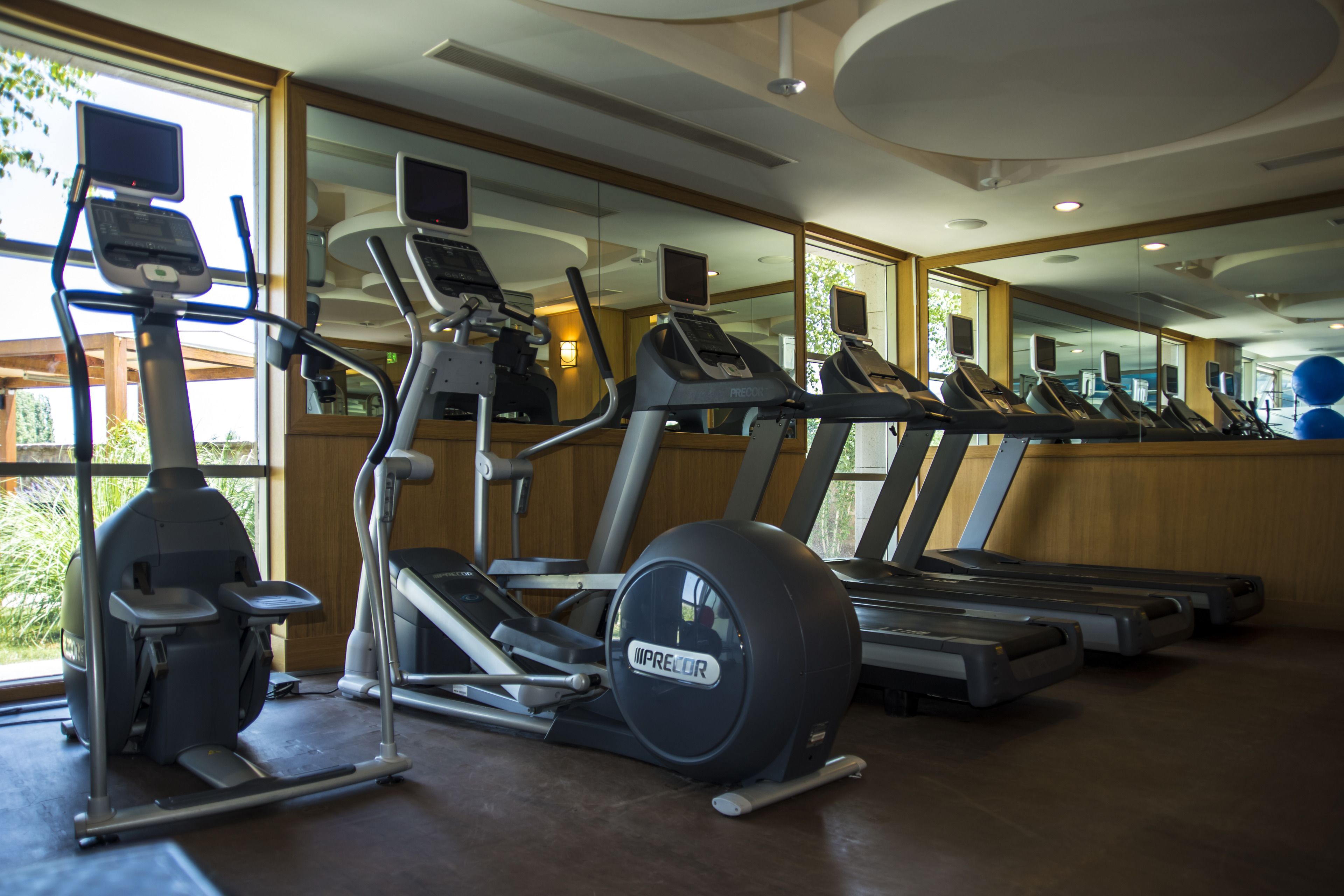 A gym with treadmills, elliptical machines, and stationary bikes.