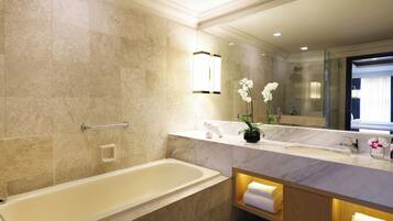 Ein modernes Badezimmer mit einer Badewanne, einem Waschtisch mit Spiegel und einer Zimmerpflanze, einer Orchidee.