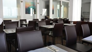 Un restaurant doté de nombreuses tables et chaises, chacune étant agrémentée d’un set de table et de couverts.