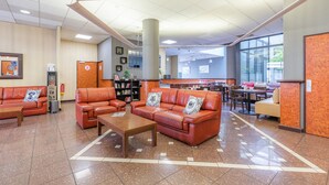 A spacious lobby with leather sofas, a coffee table, and a large pillar. - Appart’City Confort Lyon Gerland (Lyon)