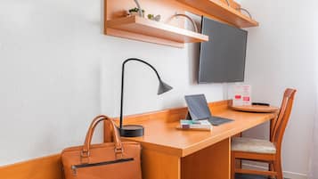 Escritorio, cortinas blackout y tabla de planchar con plancha
