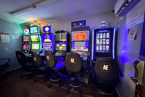 Eine Reihe von Spielautomaten mit Sitzgelegenheiten davor.