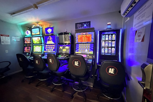 A row of gaming machines with chairs in front.