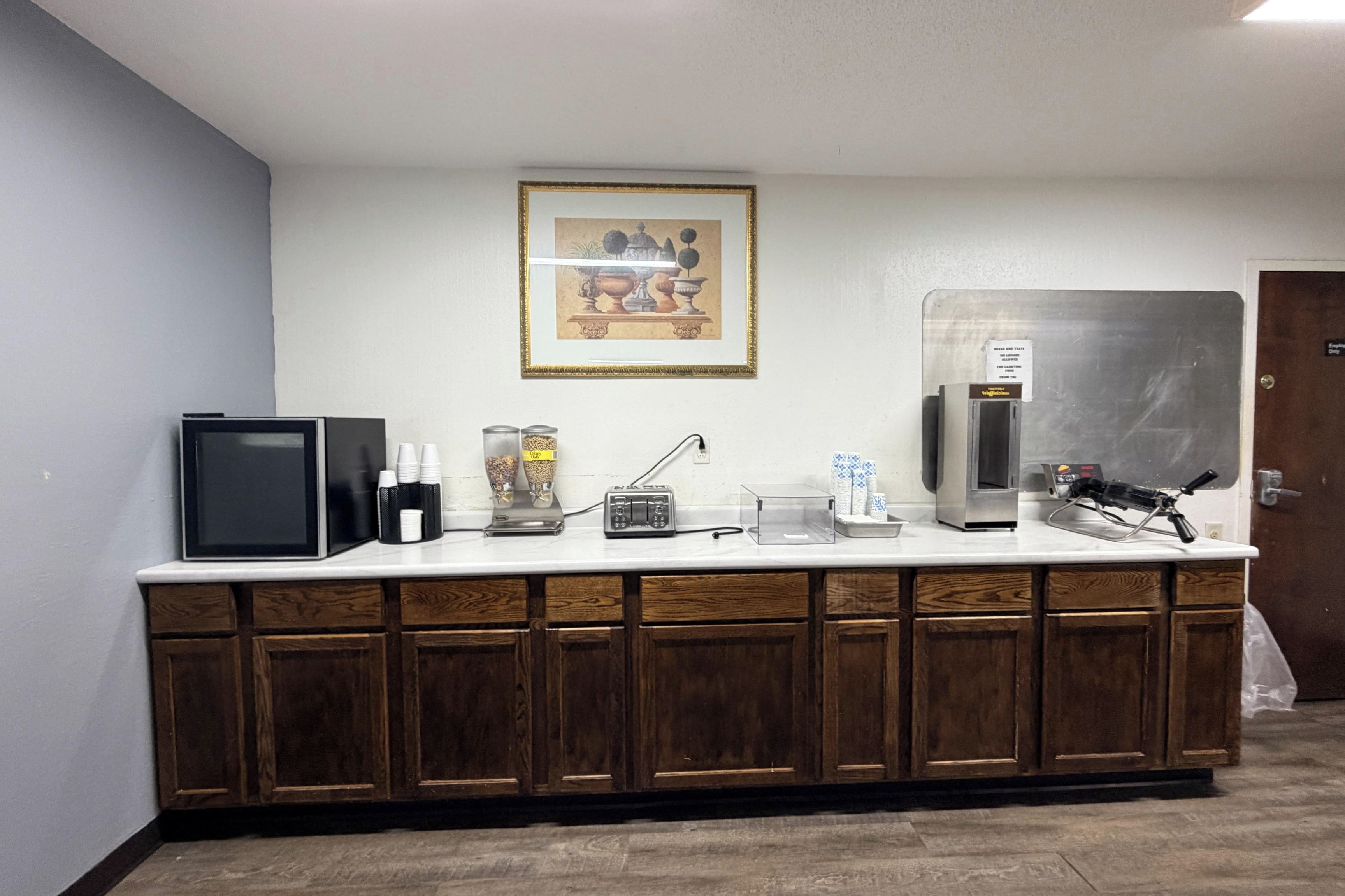 A kitchenette with a microwave, coffee maker, and a refrigerator.