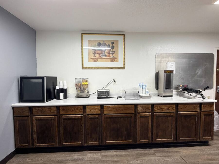 Una kitchenette equipada con microondas, cafetera y refrigerador.