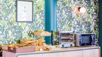 Una zona de bufé con cestas de pan, un horno tostador y un microondas.