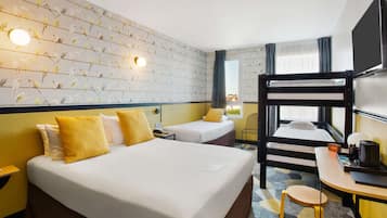 Una camera d'albergo con un letto grande, una scrivania, un letto a castello e una parete decorata.
