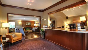 A hotel lobby with a reception desk, seating area, and a view of the adjacent room. - Earthbox Inn & Spa (Friday Harbor)