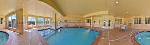 A large indoor swimming pool with multiple lanes, a lifeguard station, and a sunroof. - Hilton Garden Inn Indianapolis/Carmel (Carmel)