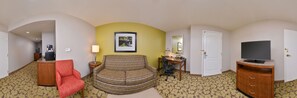 A hotel room with a desk, chair, television, and a sofa. - Hilton Garden Inn Indianapolis/Carmel (Carmel)